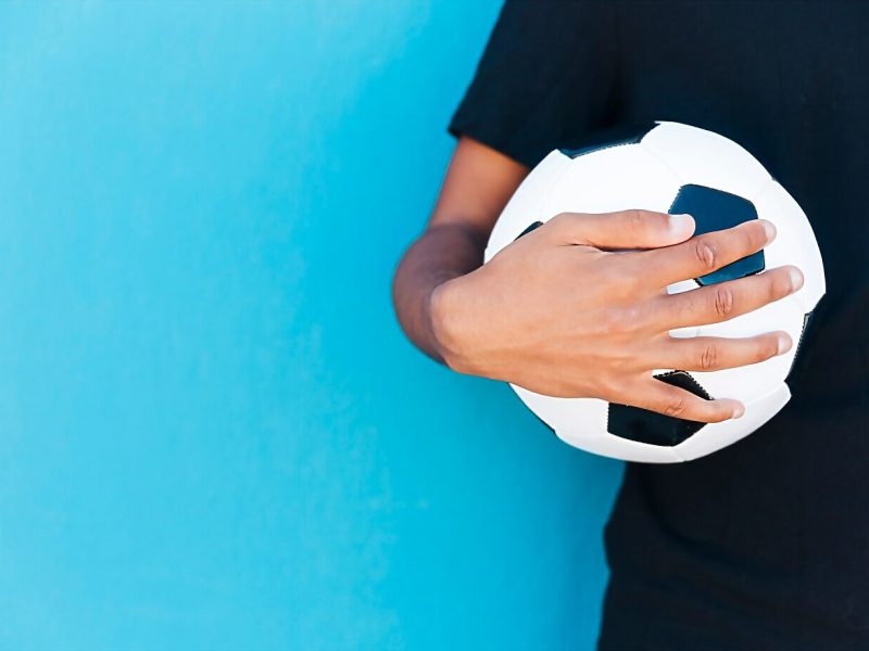 crop-arm-holding-soccer-ball-near-wall_23-2148203529 crop-arm-holding-soccer-ball-near-wall_23-2148203529